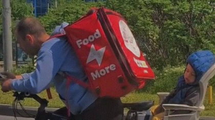 Imagini emoționante cu un curier care își transportă pe bicicletă copilul adormit. Clipul a devenit viral pe TikTok