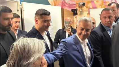 Călin Georgescu, așteptat ca Mesia la secția de votare. Românii s-au înghesuit să-i pupe mâna și să-i ofere flori VIDEO